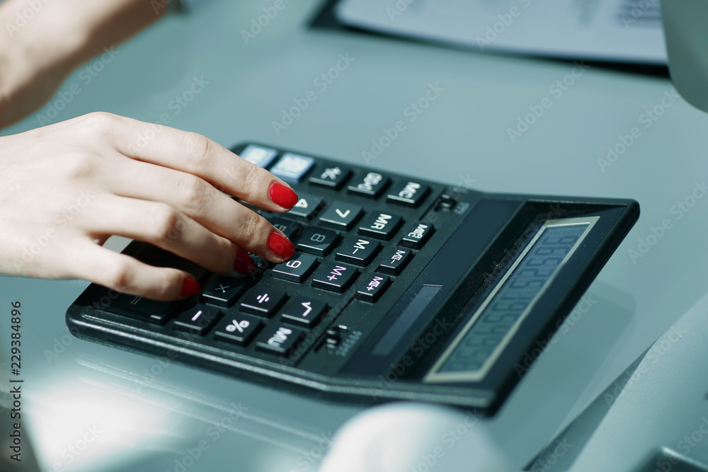 .closeup.business woman using a calculator at the workplace. .closeup.business woman using a calculator at the workplace.
