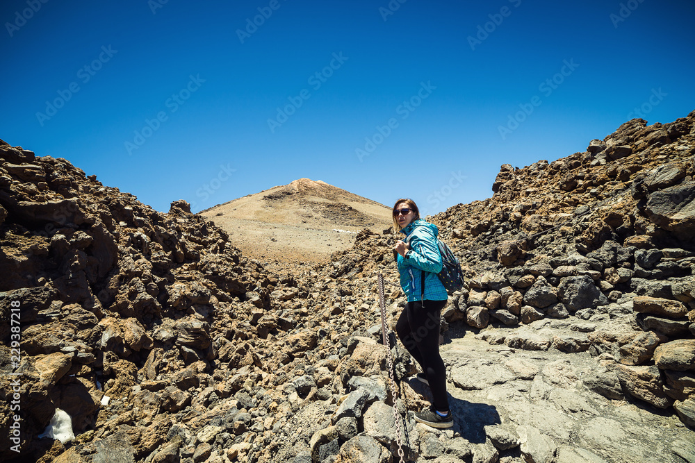 girl over the clouds on top of the mountain by the volcano Teide, Tenerife, Canary Island, Spain