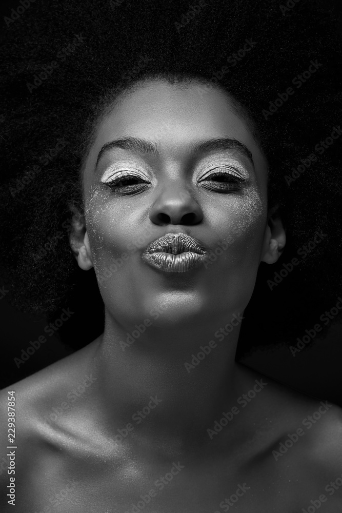 © LIGHTFIELD STUDIOS - black and white photo of attractive african american woman with duck face isolated on black