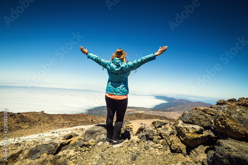 girl over the clouds on top of the mountain by the volcano Teide, Tenerife, Canary Island, Spain