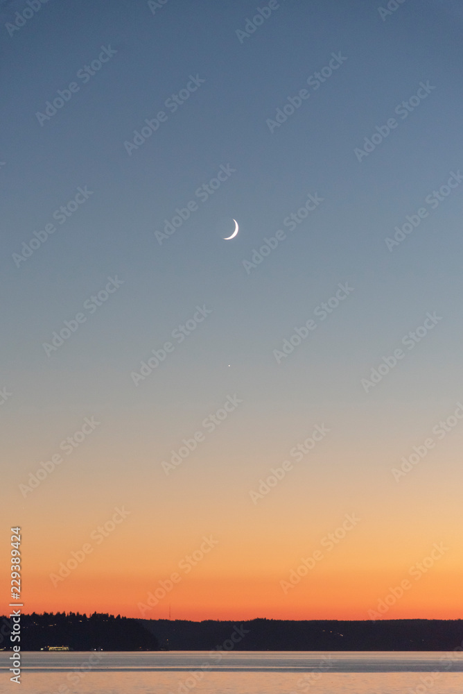 Crescent moon over horizon puget sound 