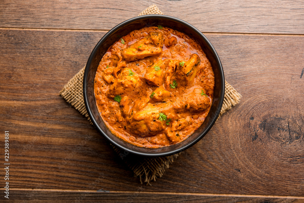 Murgh Makhani / Butter chicken tikka masala served with roti / Paratha and plain rice along with onion salad. selective focus Murgh Makhani / Butter chicken tikka masala served with roti / Paratha and plain rice along with onion salad. selective focus