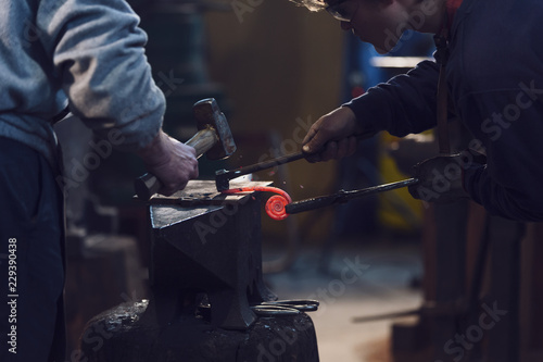 Two men working in a metalworking workshop
