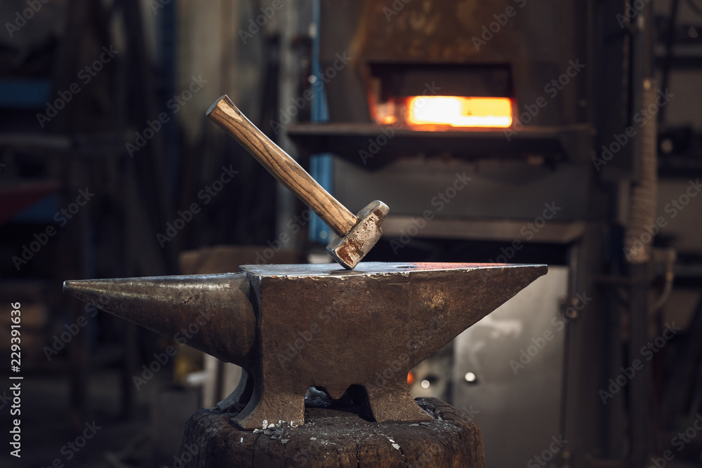 Mallet on an anvil in front of a furnace Mallet on an anvil in front of a furnace