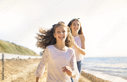 Mother and daughter having fun  running at the beach
