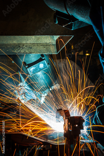 worker with protective mask welding metal