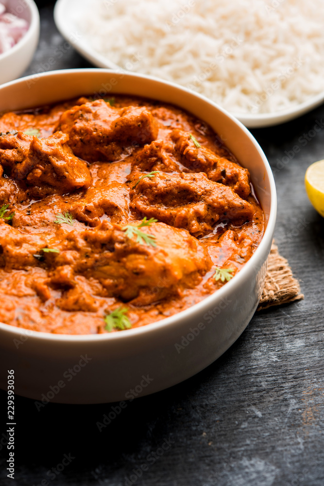 Murgh Makhani / Butter chicken tikka masala served with roti / Paratha and plain rice along with onion salad. selective focus Murgh Makhani / Butter chicken tikka masala served with roti / Paratha and plain rice along with onion salad. selective focus