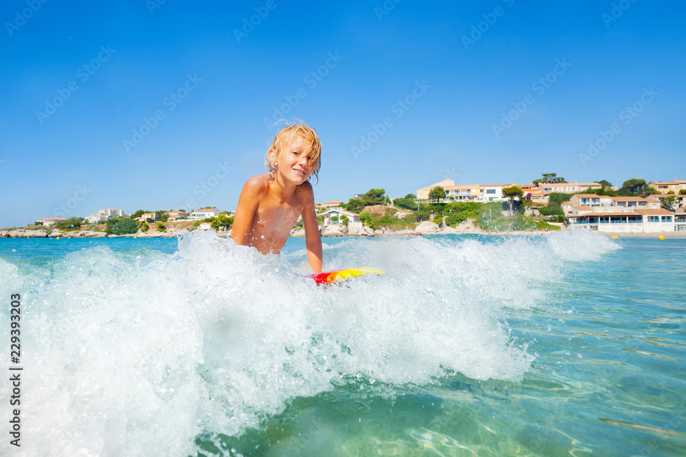 Active teenage boy riding the wave on body board