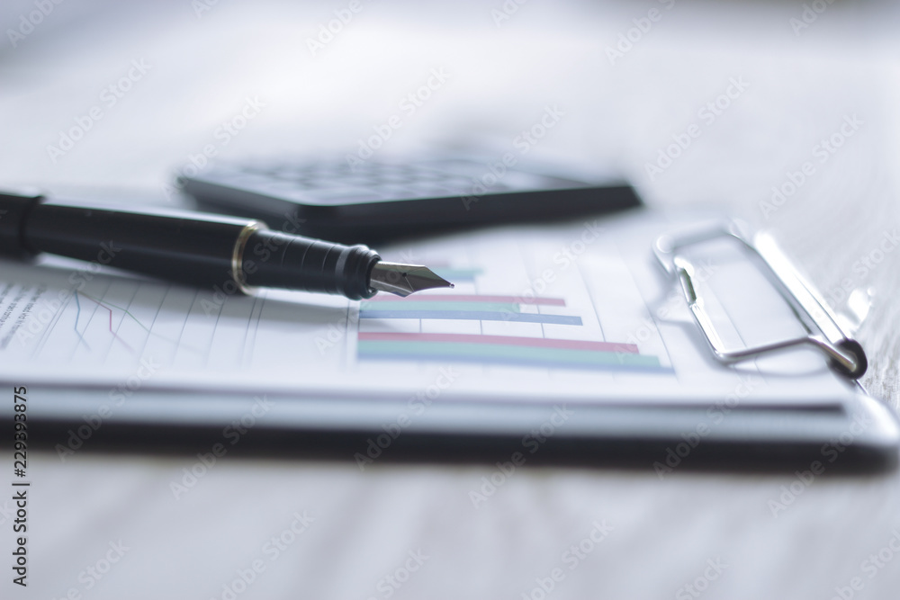 close up. gold-tipped pen and financial chart on the table close up. gold-tipped pen and financial chart on the table