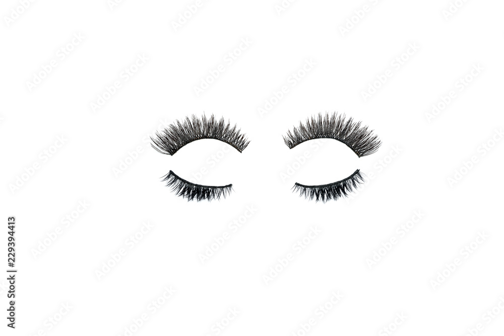 Dramatic black long false eyelashes placed in the shape of a human eye isolated on white background shot with studio light Dramatic black long false eyelashes placed in the shape of a human eye isolated on white background shot with studio light