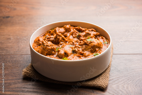 Murgh Makhani / Butter chicken tikka masala served with roti / Paratha and plain rice along with onion salad. selective focus photo