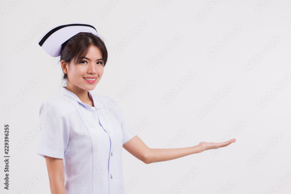 happy, smiling, friendly asian female nurse pointing up or showing something, studio isolated of young adult asian woman model on medical nurse role happy, smiling, friendly asian female nurse pointing up or showing something, studio isolated of young adult asian woman model on medical nurse role