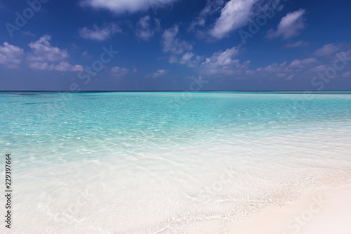 Tropischer Traumstrand mit t  rkisem Wasser und feinem Sand unter tiefblauem Himmel