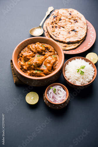 Murgh Makhani / Butter chicken tikka masala served with roti / Paratha and plain rice along with onion salad. selective focus