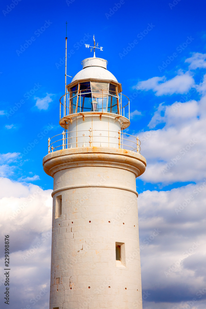 White lighthouse against blue sky with clouds