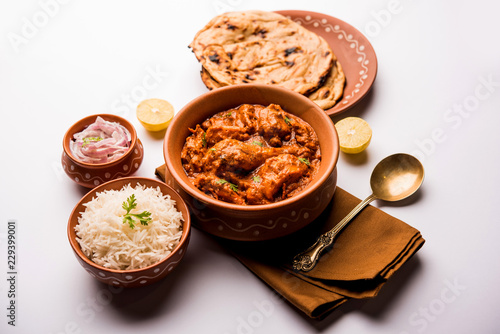 Murgh Makhani / Butter chicken tikka masala served with roti / Paratha and plain rice along with onion salad. selective focus photo