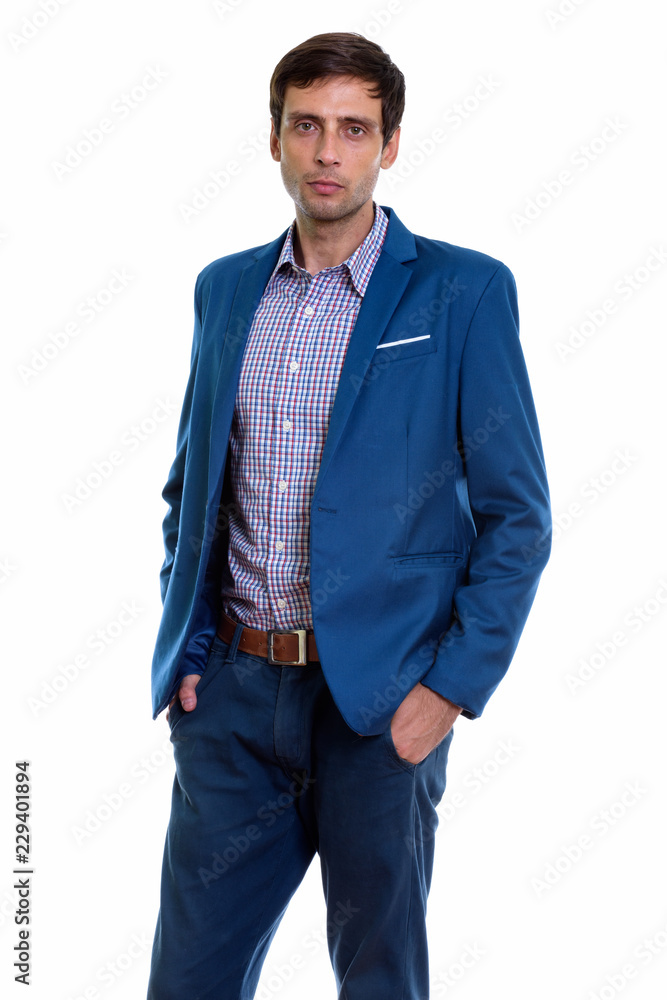 Studio shot of young handsome businessman standing with hands on Studio shot of young handsome businessman standing with hands on