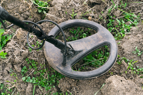 Search for gold, metal detector lies on the ground, searches in the ground