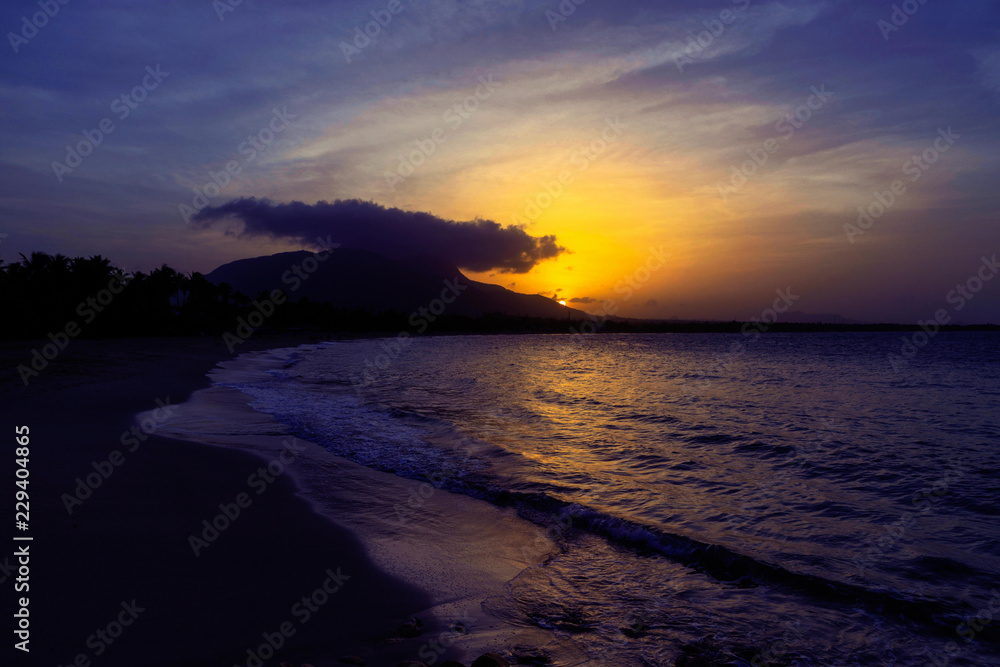 Sunset in yellow and purple shades with a reflection in the sea, Puerto Plata, Dominican Republic, Caribbean.