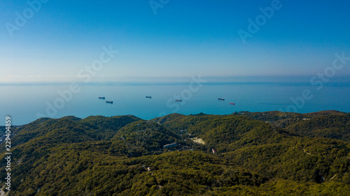 The Black Sea coast, the area of Sochi, the federal highway, on which cars drive, winding road among the trees, passing through the mountains along the coast.