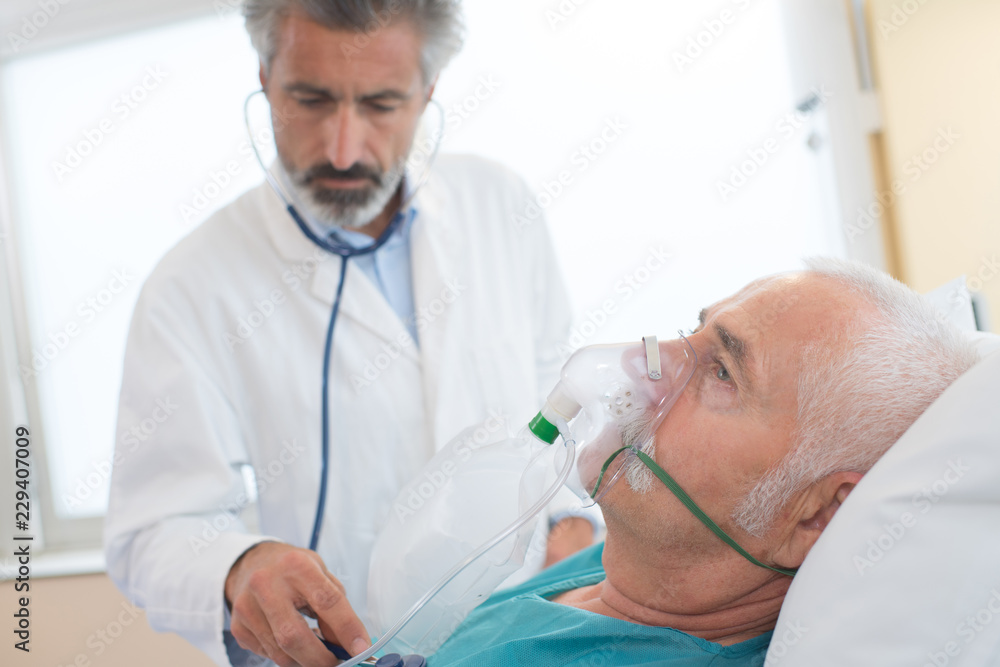 worried doctor holding oxygen mask in hospital room worried doctor holding oxygen mask in hospital room