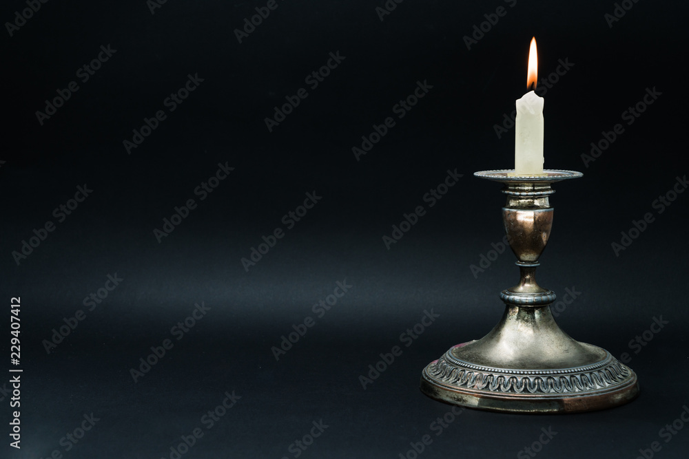Old silver candle holder with lighted candle Old silver candle holder with lighted candle