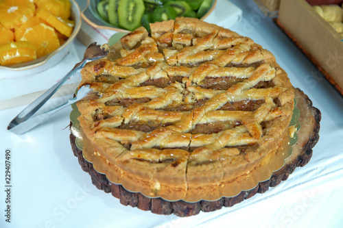 Yellow patterned cake . yellow cream, decorated with cherries and grapes, closeup