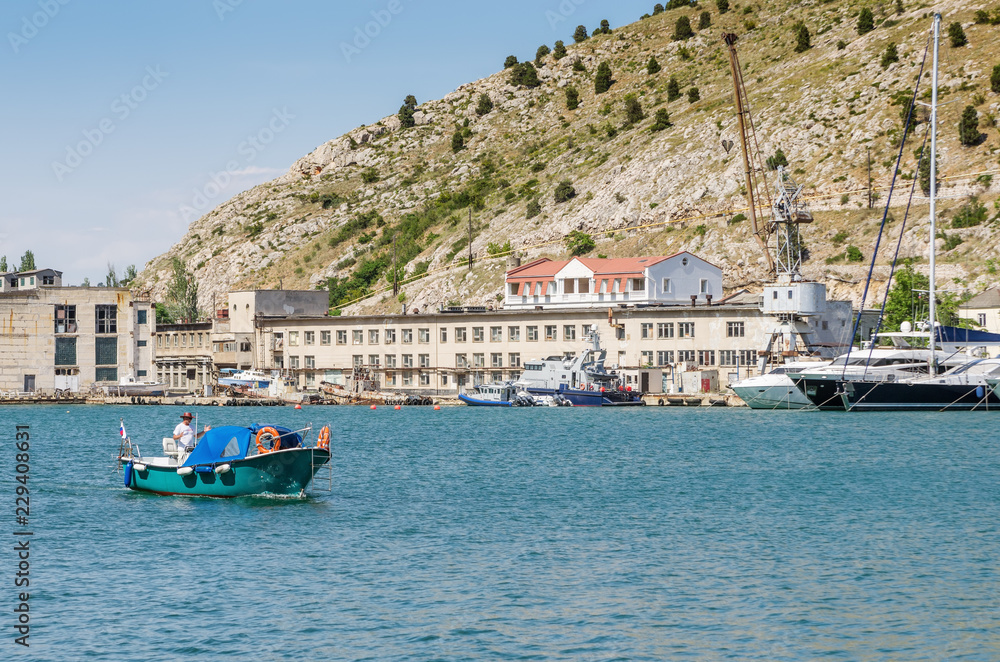 Pleasure boat in the sea bay. Russia, Republic of Crimea, Balaclava. 11.06.2018: Pleasure boat with tourists in Balaklava Bay Pleasure boat in the sea bay. Russia, Republic of Crimea, Balaclava. 11.06.2018: Pleasure boat with tourists in Balaklava Bay