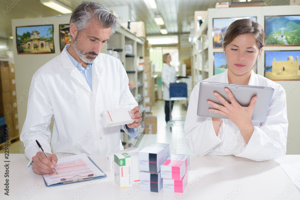 pharmacists holding tablet in hands while doing inventory