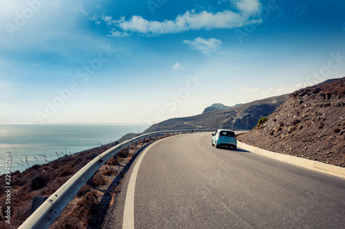 Blue small car rides along a serpentine mountain road along the sea, Kos island, Greece photo