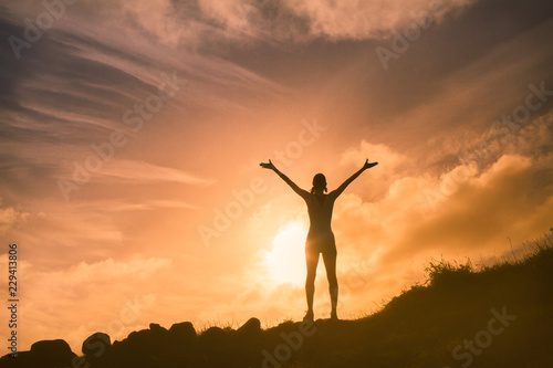 Silhouette of woman with her arms raised photo