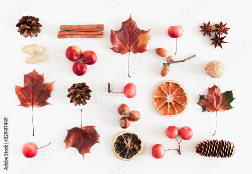 Autumn, fall concept. Pattern made of cinnamon sticks, star anise, pine cones, berries, dried orange, leaves on white background. Flat lay, top view 