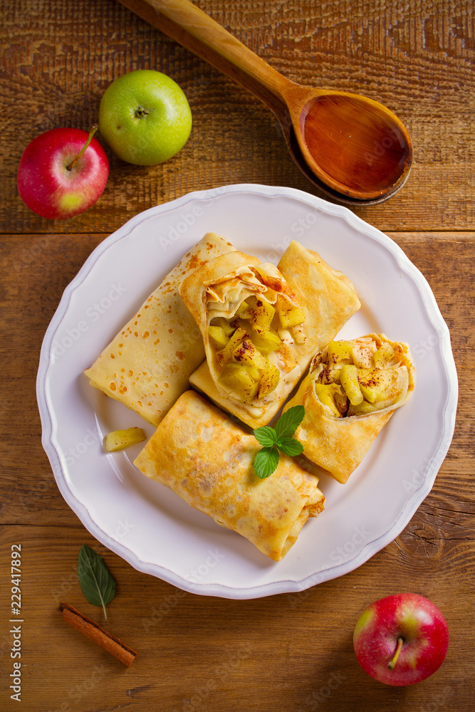 Delicious homemade crepes filled with apples and cinnamon. overhead, vertical