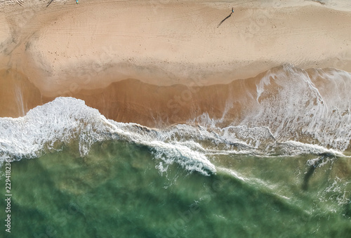 Aerial drone view of a beach, people walking