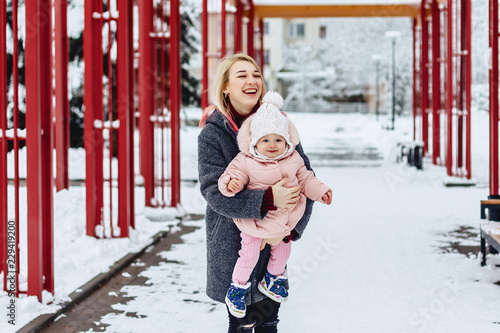 stylish mom with baby walk at street on winter