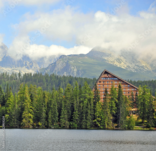 Wooden house in forest under mountains photo