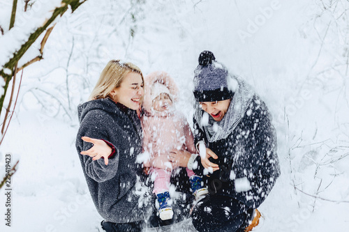 happy young family walks with baby on winter street, mom, dad, child