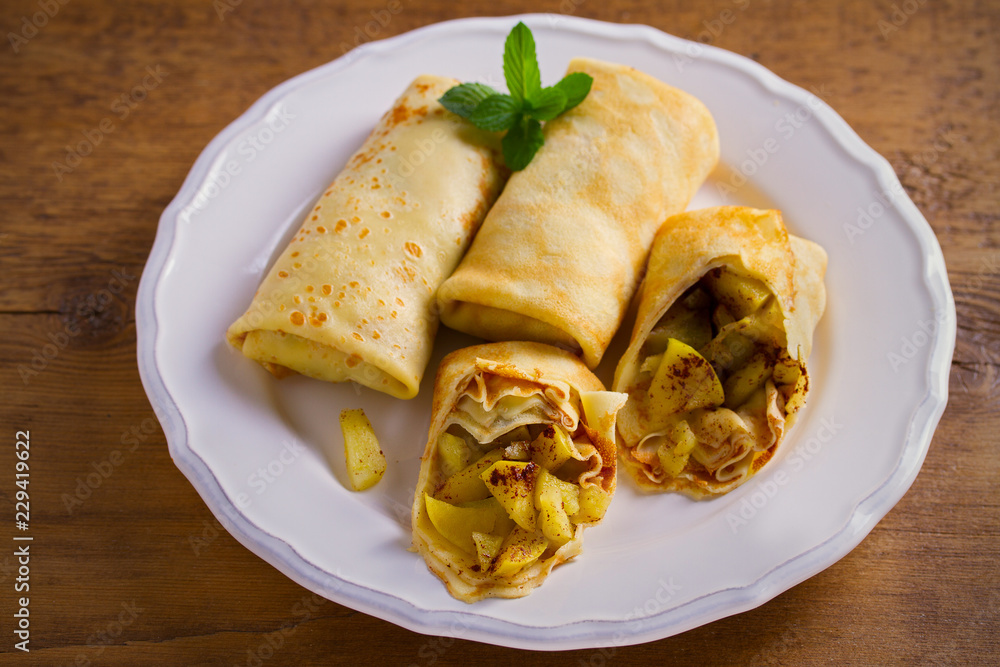 Delicious homemade crepes filled with apples and cinnamon. horizontal