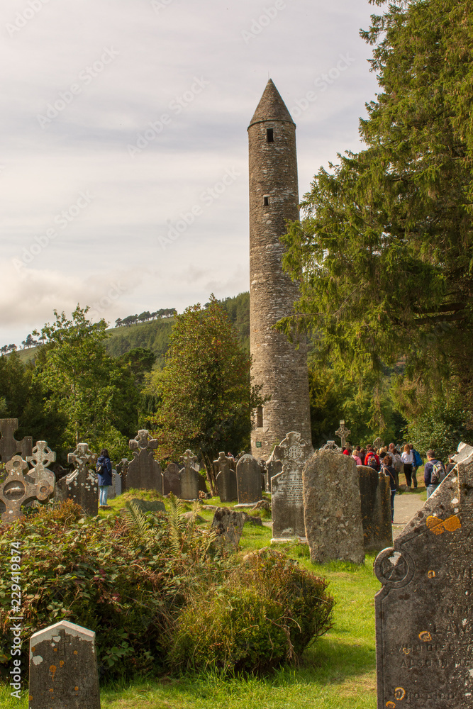 Celtic cemetery and stone tower in Irish countryside