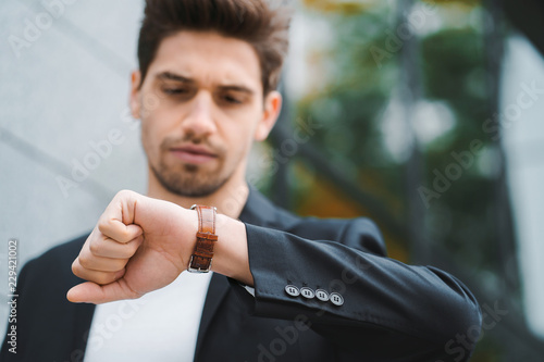 Картината върху платно Handsome businessman or student looks at watch