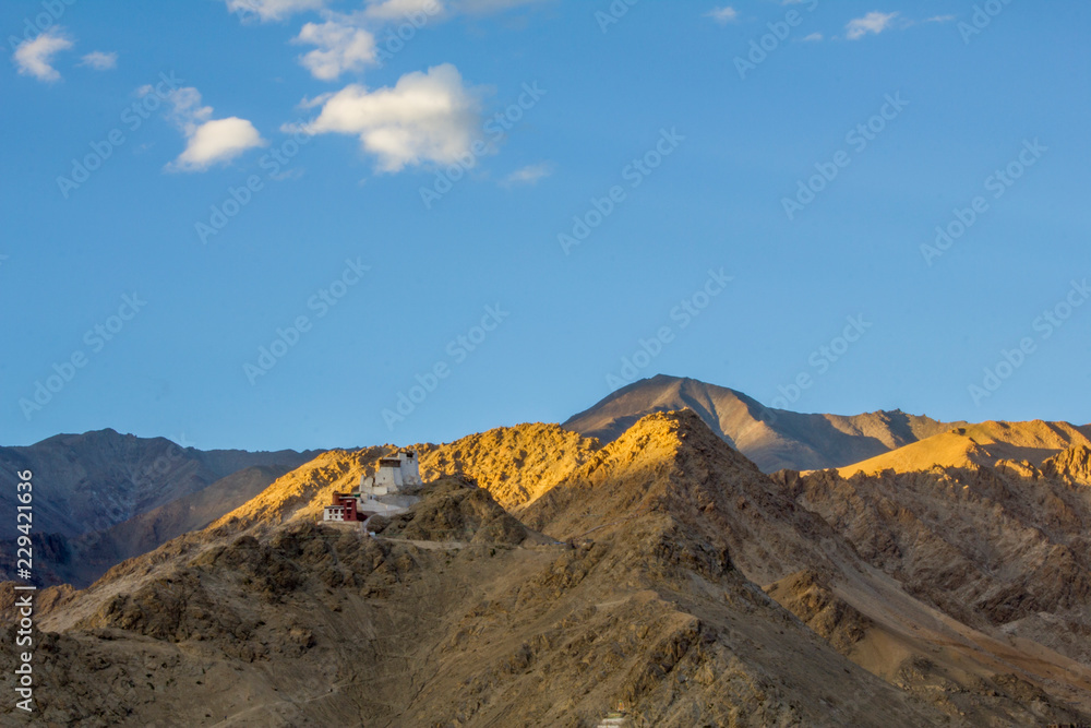 rays of the setting sun over the Tibetan temple in the mountains