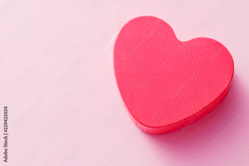 Fototapeta premium Red heart on a pink background, top view