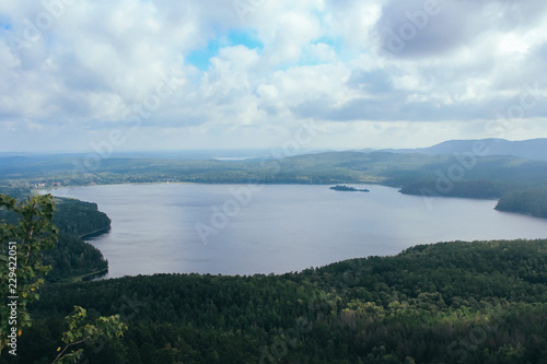 View from the mountain to the lake and forest cloudy sky