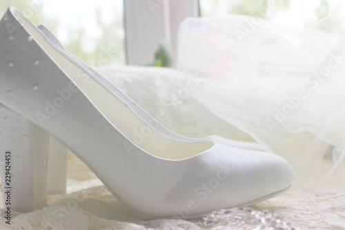 The background of the wedding day. White on white. White shoes. wedding shoes. Bride`s high heels. The fees of the bride. Wedding jewelry.