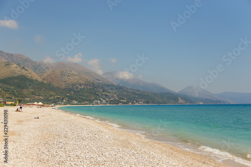 View on the Borsh Beach in Albania. Stony beach on the Adriatic Sea. Mountain in the background.