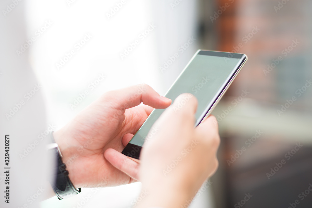 Close-up of unrecognizable man touching smartphone screen while zooming information. Businessman checking sms on phone. Technology concept