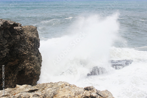 Big splash in the ocean against rock