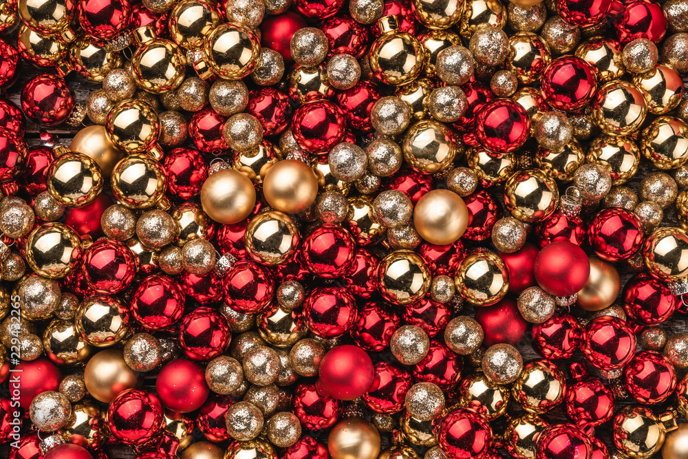 Christmas card. Wallpaper of red and gold baubles. Top view.