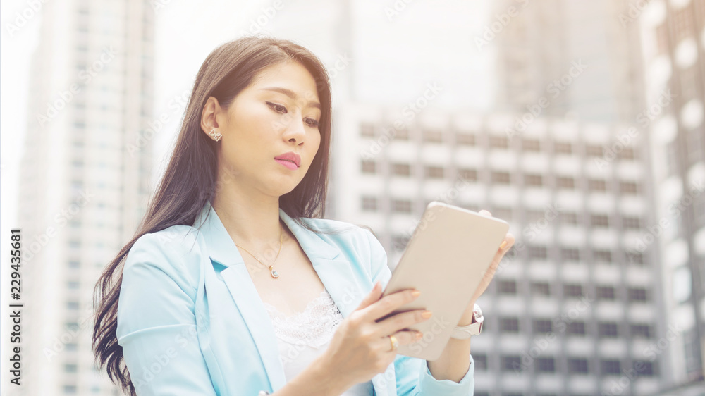 Beautiful cute girl  business woman clothes holding a smart phone, urban city background