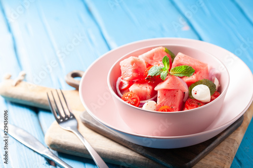 Healthy organic watermelon salad with feta and mint in pink bowl